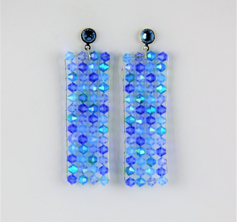 Boucles d'oreilles en perles SWAROVSKI® ELEMENTS bleues, montées sur un cadre en fil d'argent massif 925 et tissées par un fil nylon transparent.